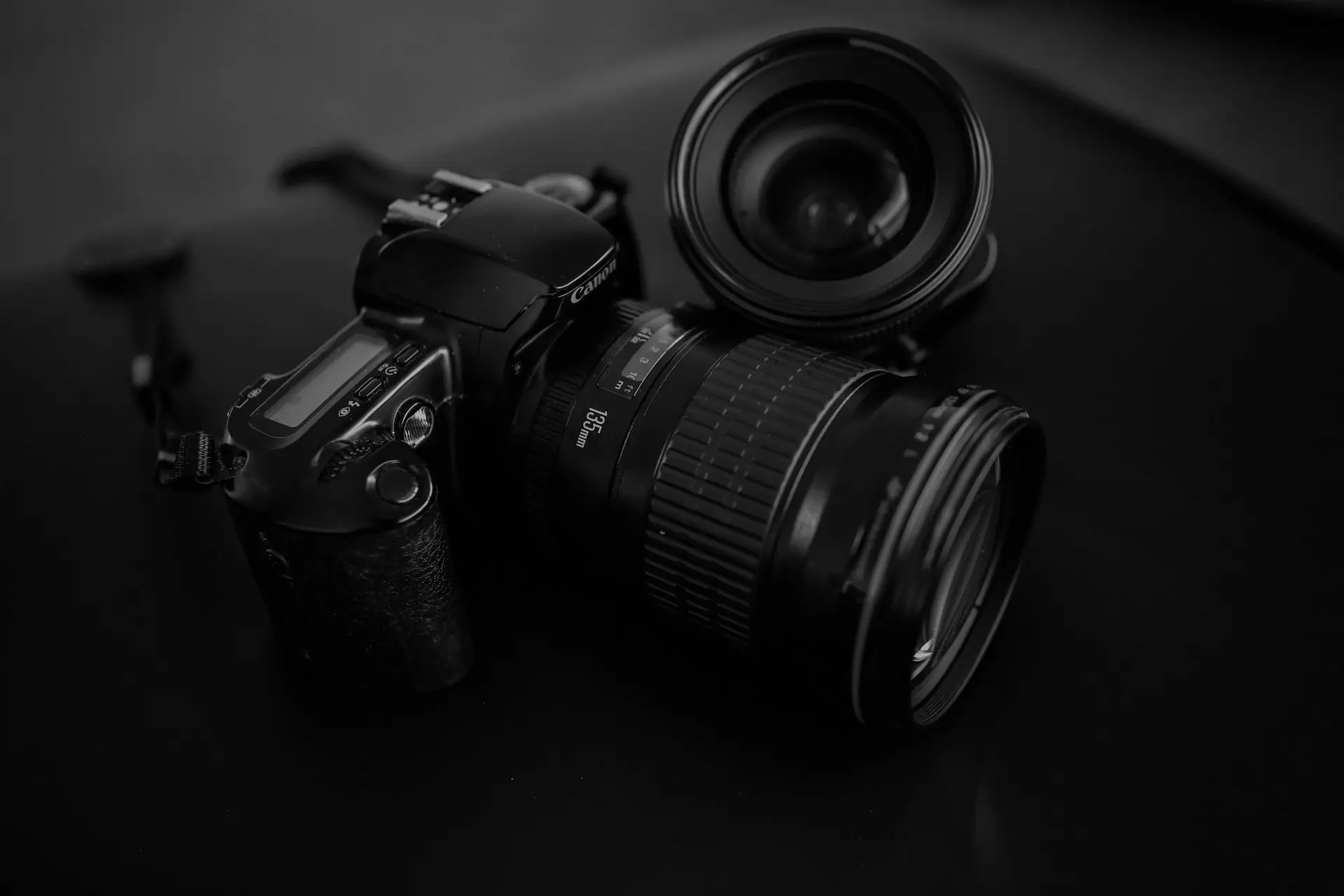 black Canon DSLR camera beside camera lens