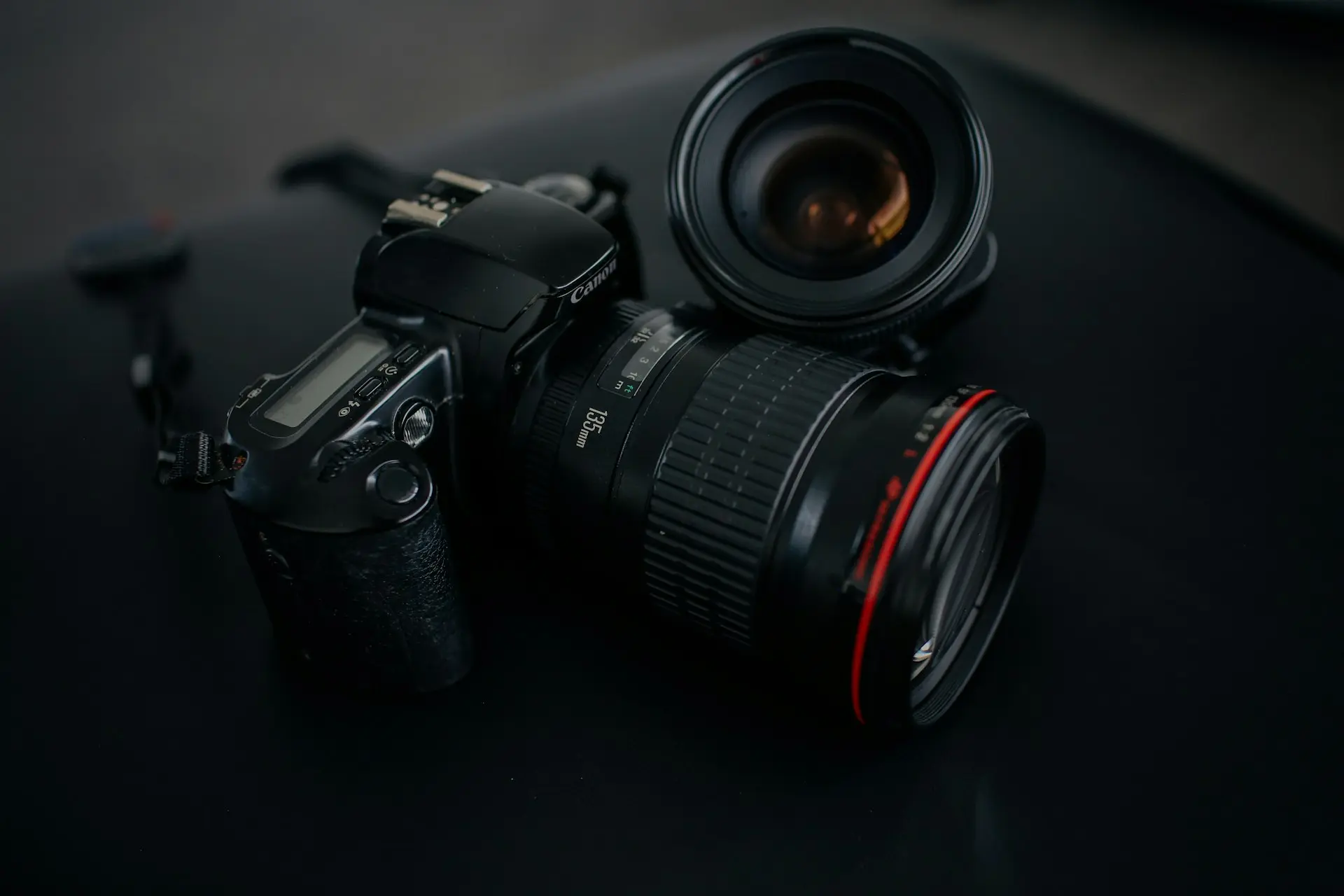 black Canon DSLR camera beside camera lens