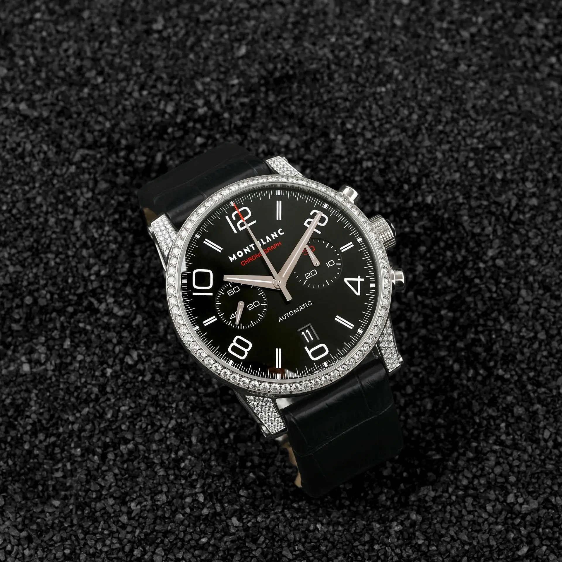 Montblanc automatic chronograph watch with a black dial, diamond-studded bezel, and black leather strap.