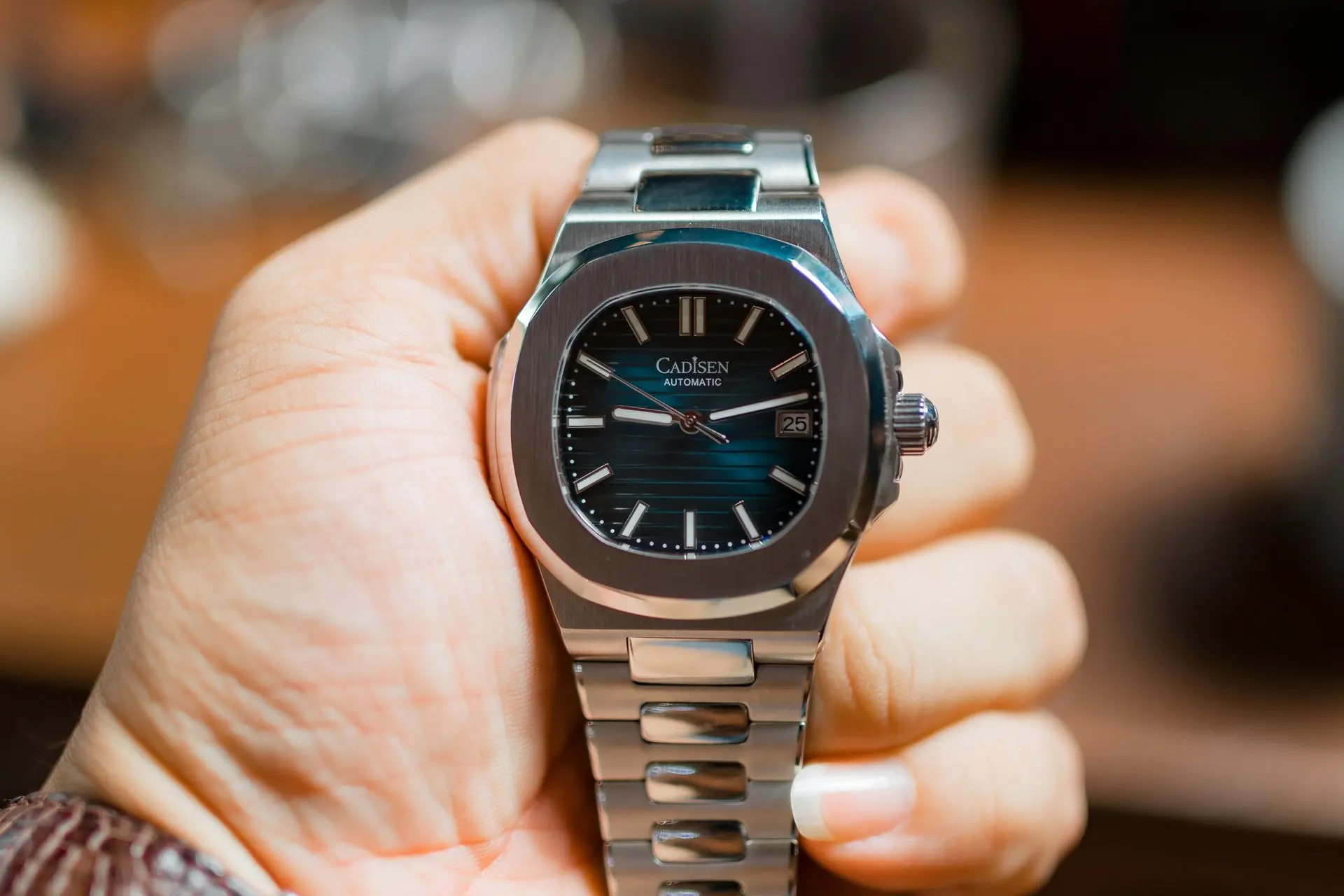 Cadisen automatic watch with a teal dial, stainless steel case and bracelet, and a date window