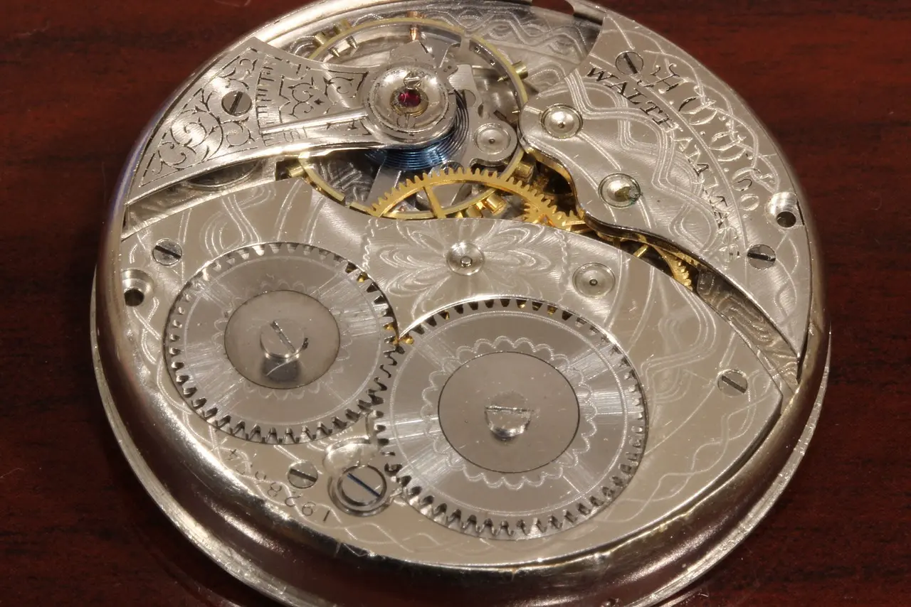 Intricate macro view of a vintage mechanical watch or clockwork movement, showing the visible brass gears, wheels, and bridges.