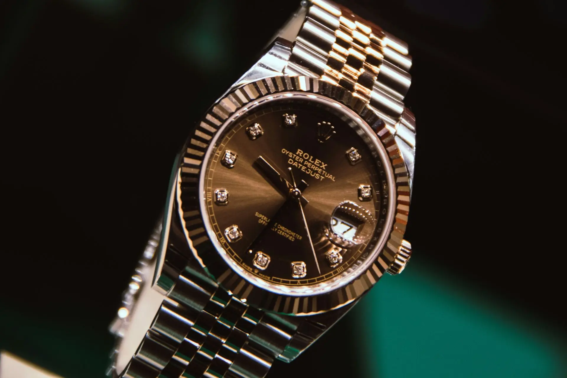 Luxurious Rolex-style watch with gold and silver tones, diamond markers, and a metal bracelet, exuding elegance
