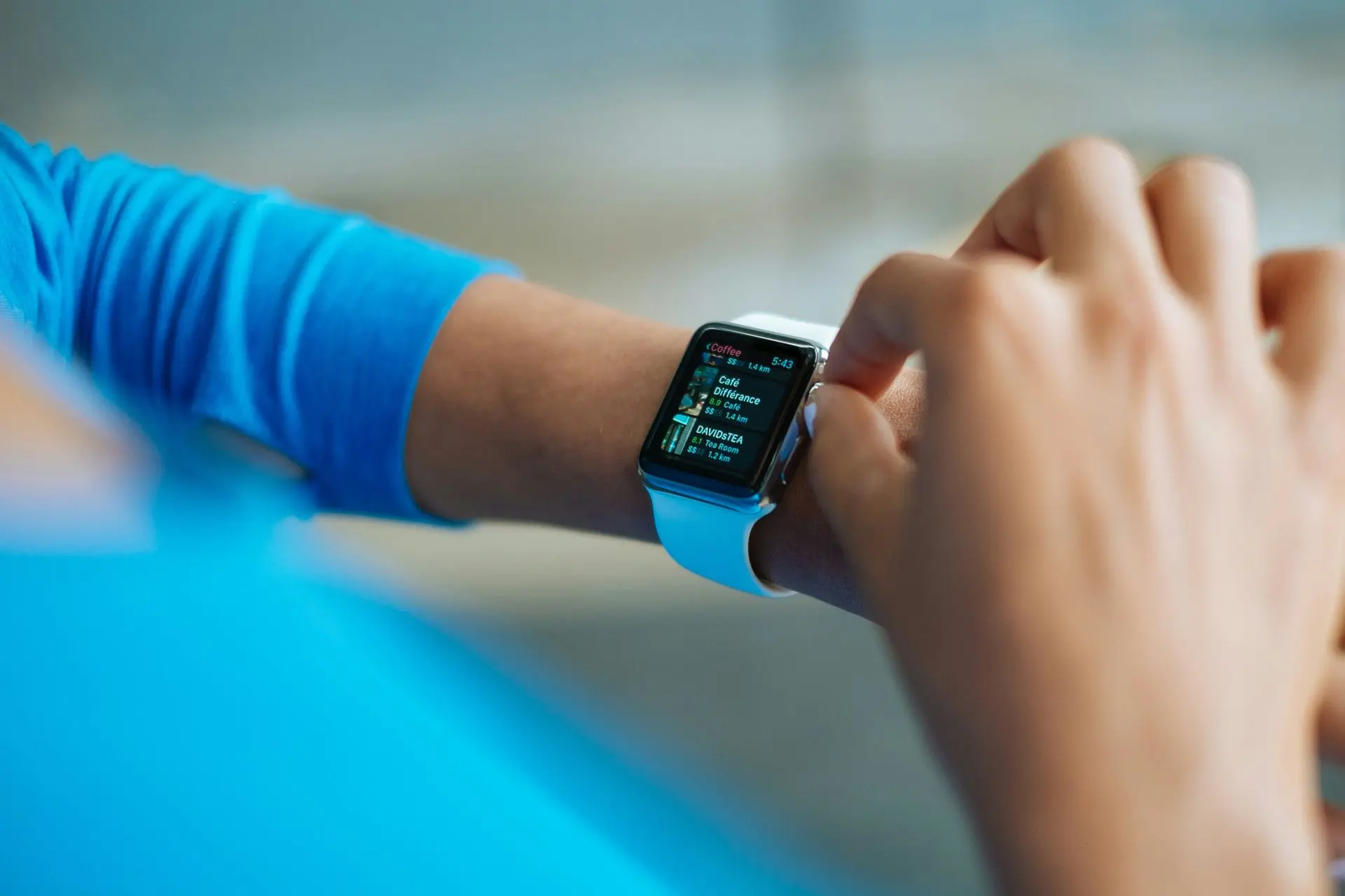 Person wearing a smartwatch with a white strap while dressed in a sporty outfit, demonstrating how a smartwatch fits into the smart watch dress code for fitness and casual wear.