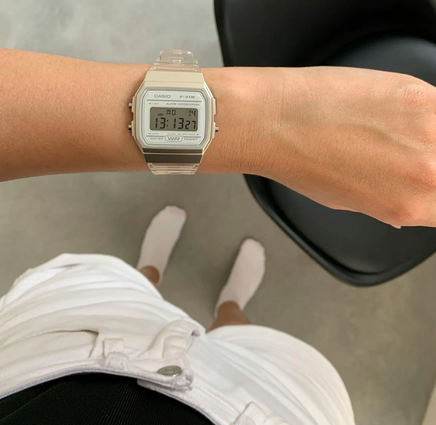 Person wearing a clear-strapped Casio digital watch paired with casual shorts and socks, showing how a digital watch fits into a relaxed digital watch dress code.
