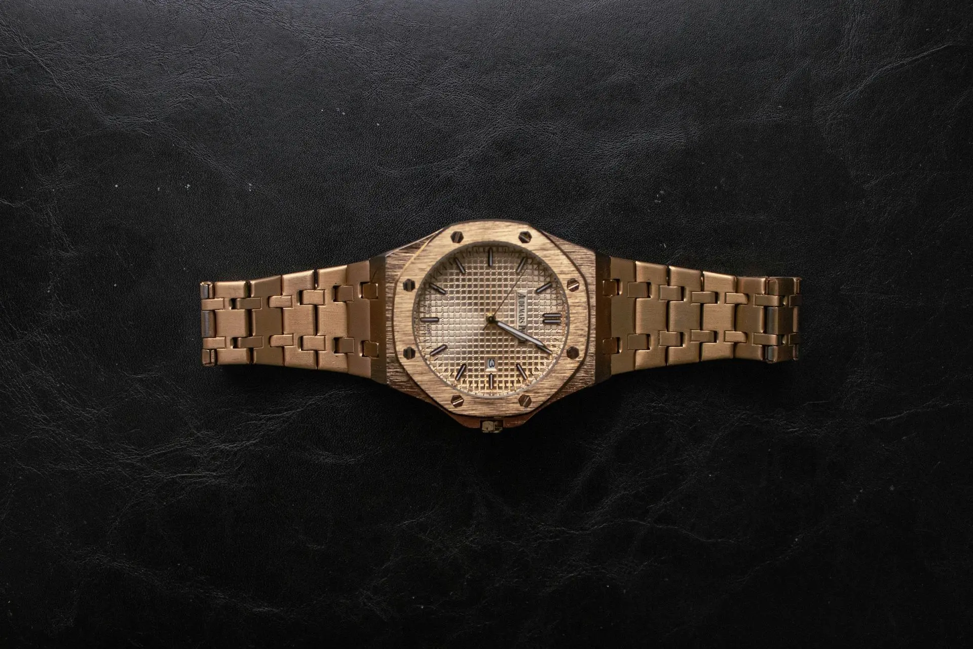 Automatic Watch Investment Audemars Piguet Gold-toned luxury watch with an octagonal bezel and textured dial displayed on a dark surface, illustrating the investment appeal of Audemars Piguet automatic watches.