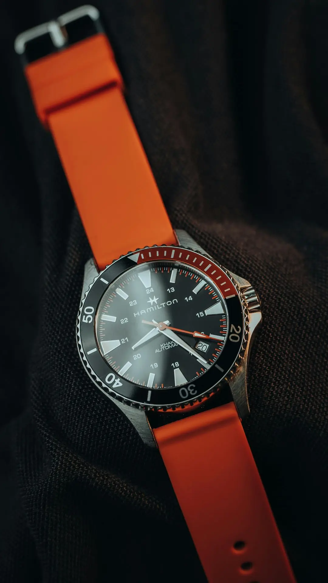 Trending styles in international watches featuring a Hamilton automatic dive watch with an orange strap