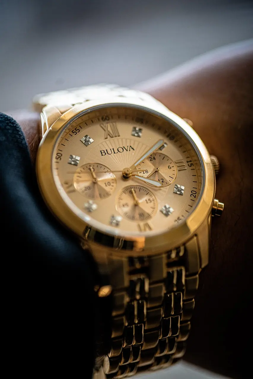 Bulova Classic gold-tone multi-function dress watch with champagne dial and stainless steel bracelet worn on the wrist.