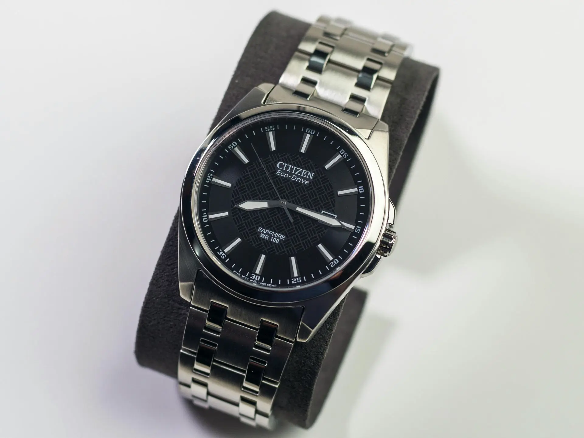 Citizen Eco-Drive watch with black dial and stainless steel bracelet on display stand