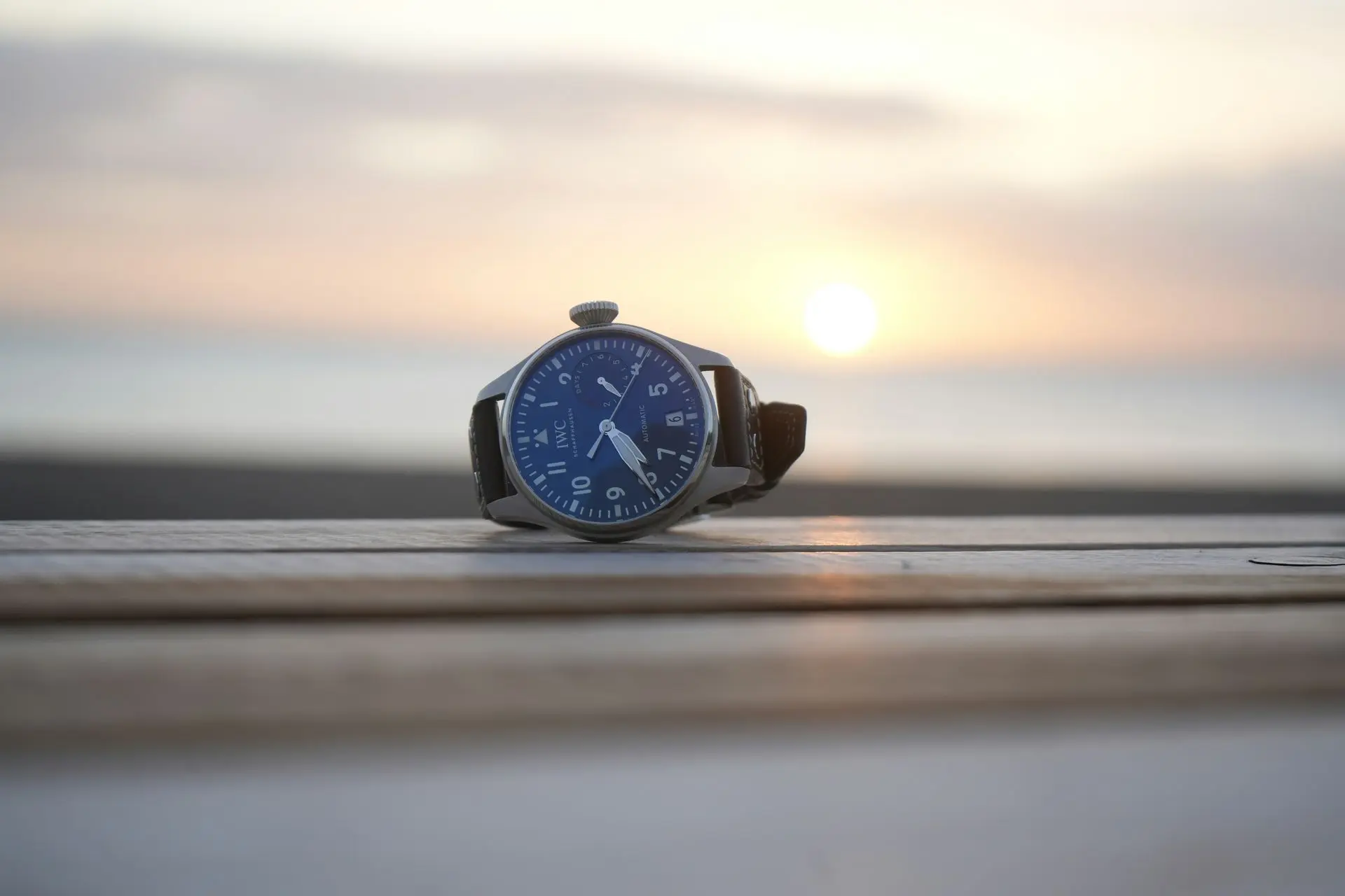 IWC Luxury Military Pilot Watch IWC luxury military pilot watch on wooden surface during sunset