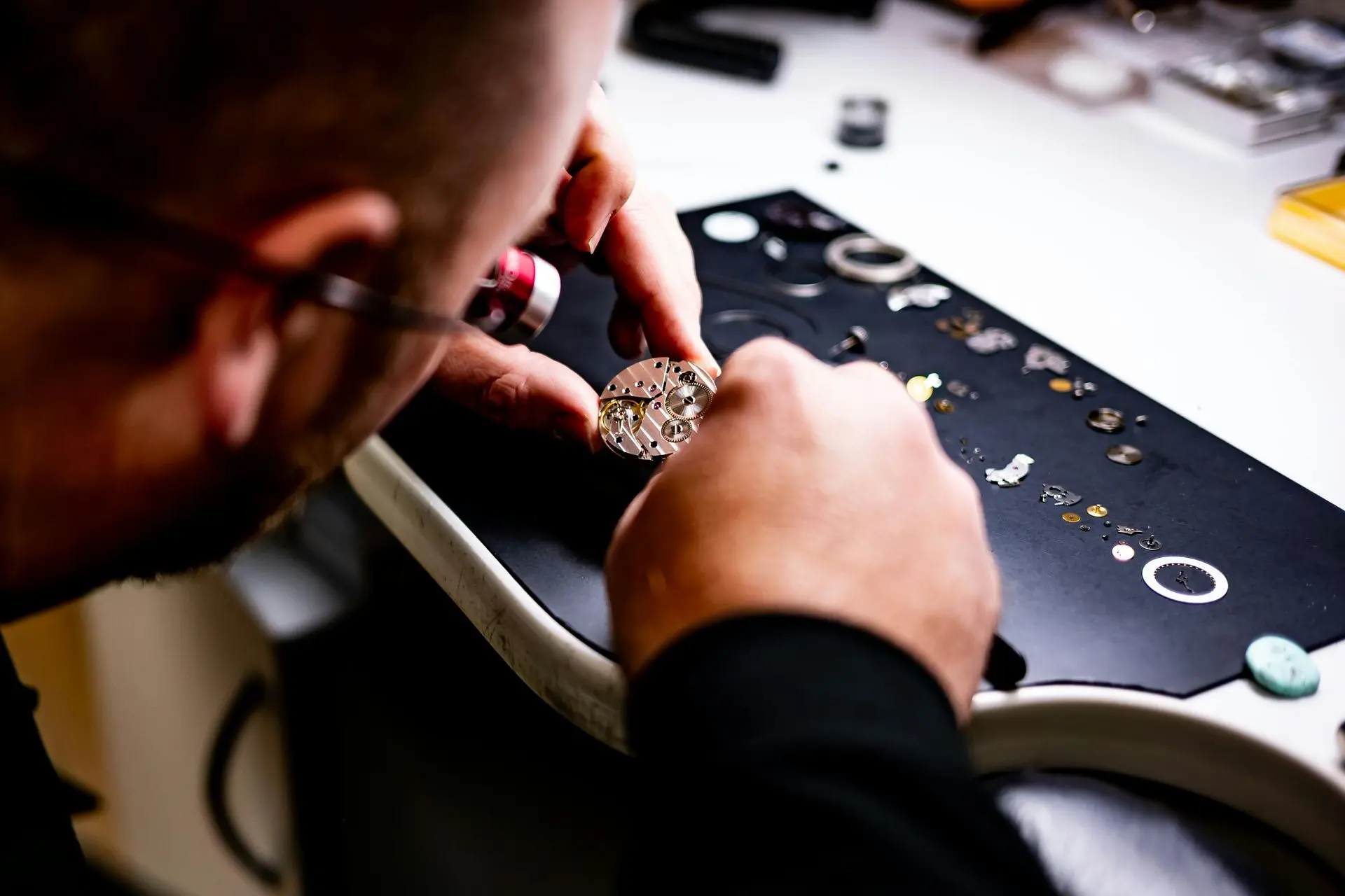 What Happens During a Professional Watch Service? Professional watchmaker performing a complete watch service on a disassembled automatic watch movement.