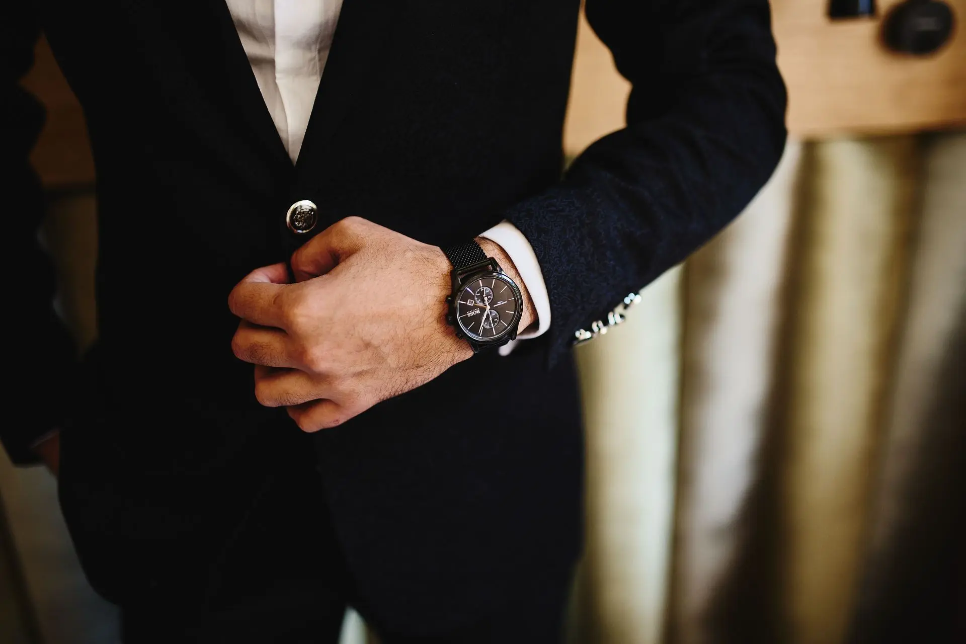 Matching Your Watch with Your Outfit for a Polished Look Man wearing a black wristwatch with a formal suit to demonstrate how matching your watch complements your outfit