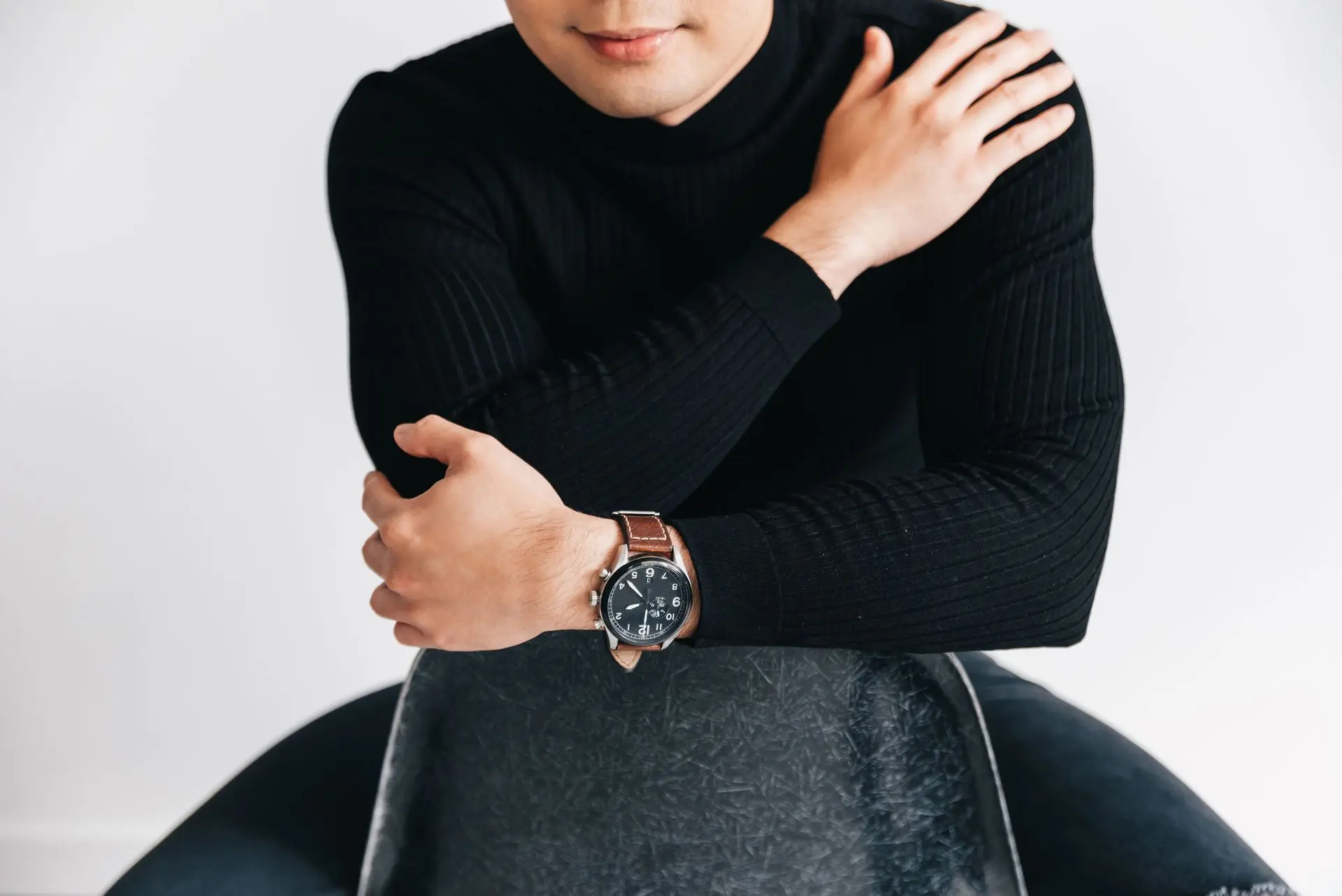 Brown Leather Strap Watch for Smart Casual Style Man wearing a brown leather strap watch with a black sweater for a smart casual everyday outfit