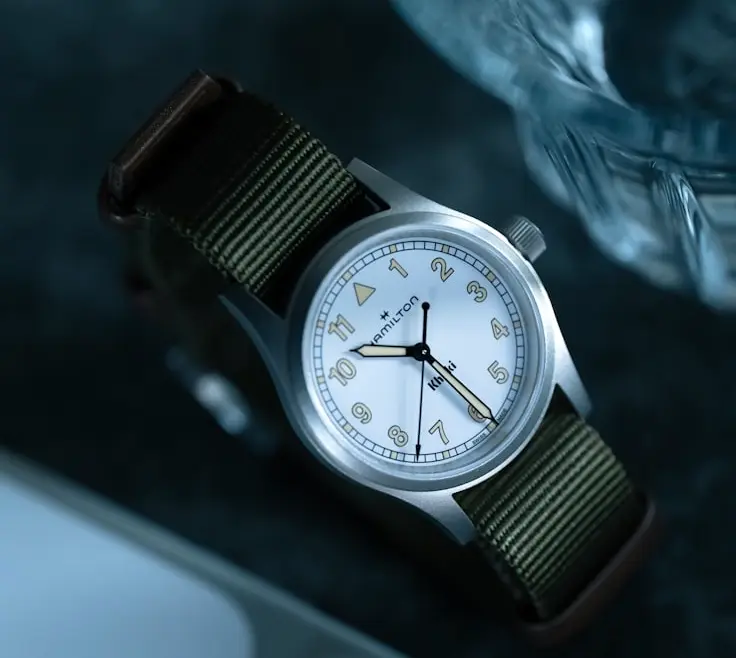 Minimalist watch collection featuring a field watch with a durable case and green fabric strap