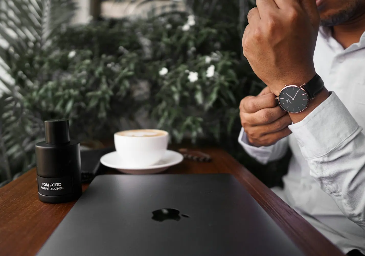 Minimalist wristwatch with leather strap worn in a modern workspace, representing convenience and contemporary watch design