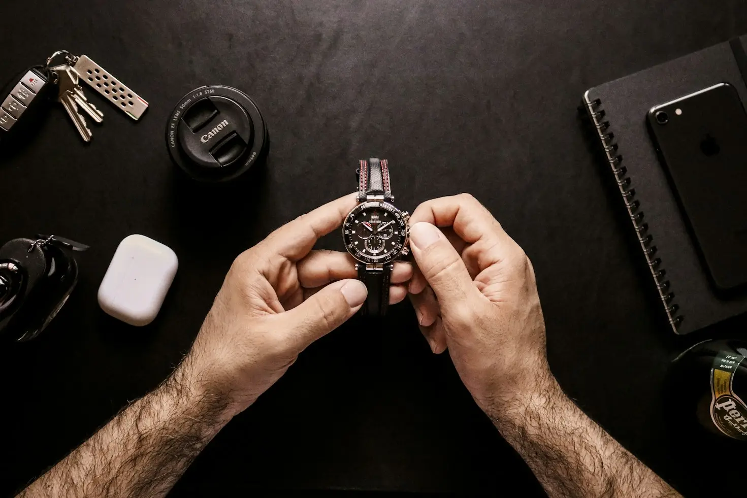 Watch enthusiast examining a mechanical watch on a desk