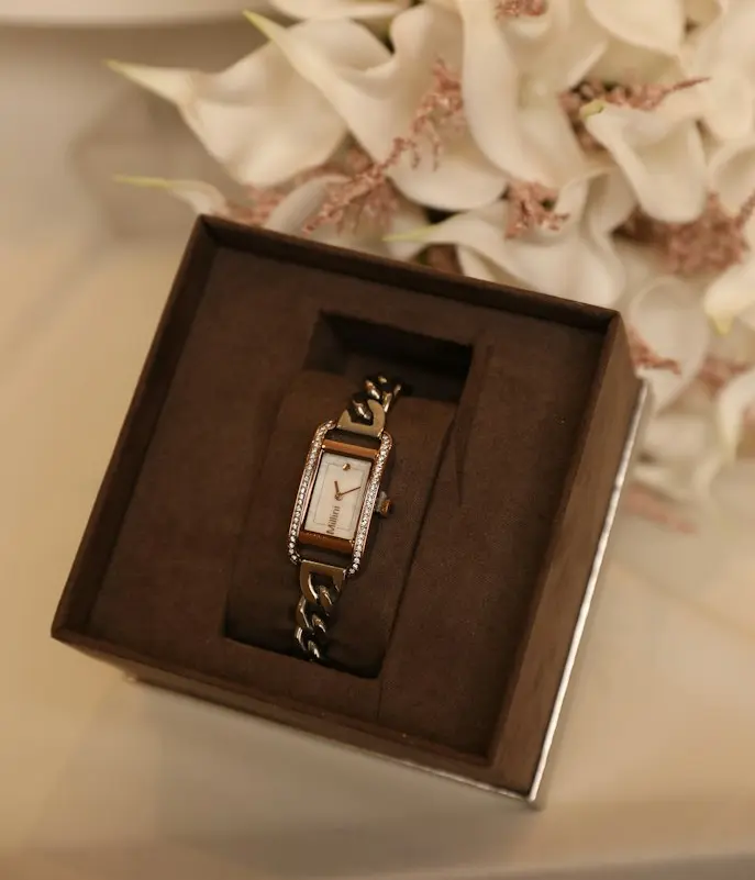 Elegant rectangular wristwatch with a gold-tone case, crystal-set bezel, and decorative bracelet displayed in a brown presentation box